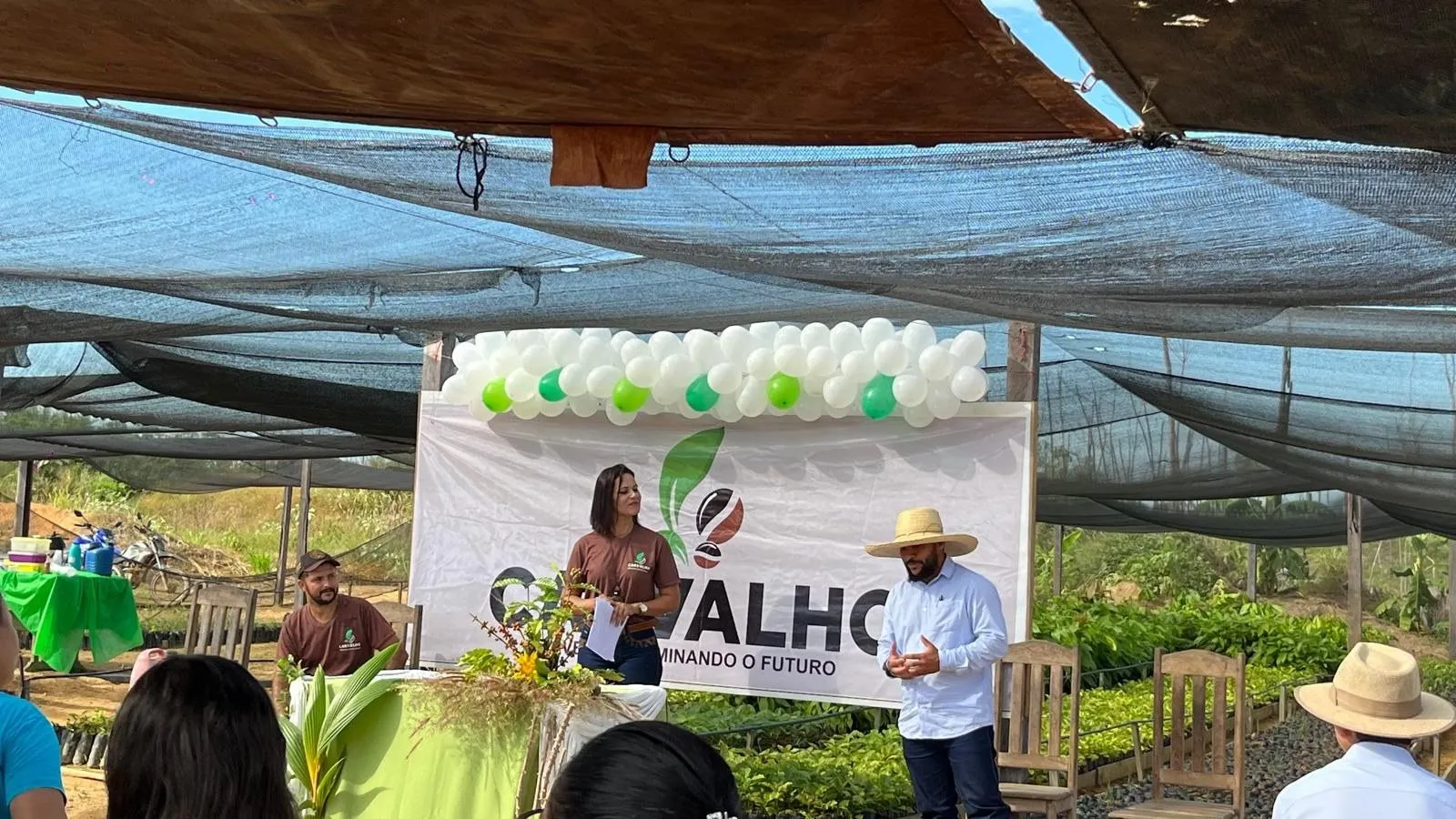 A member addressing an audience beneath the Carvalho banner at the cooperative's nursery.