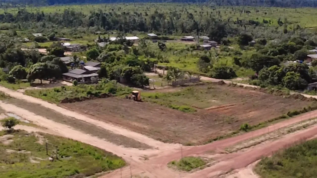 Aerial view of Taquaruçu do Norte: dirt roads, houses and cleared plots, with forest on the horizon.